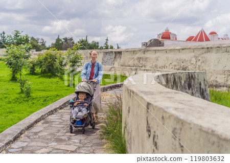 Mom and her baby son tourists exploring the Loreto Fort Museum in Puebla, Mexico. Cultural heritage, history, and travel exploration concept 119803632