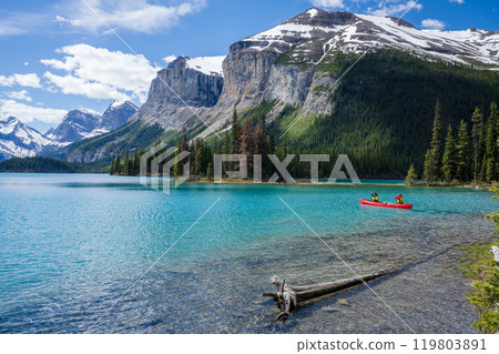 People canoeing on Maligne Lake near the spirit island. Snow-capped mountains and turquoise lakes scenery in Jasper National Park, Alberta, Canada. Canadian Rockies. 119803891