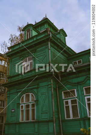 A green, wooden, old building of unusual shape 119804802