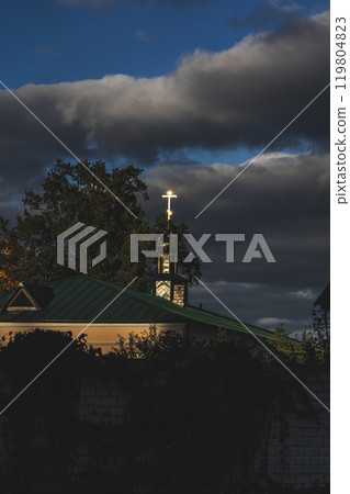 The golden cross reflects the sunny evening light. The church at sunset The golden cross reflects the sunny evening light. The church at sunset 119804823