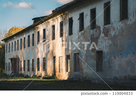 Boarded-up windows of an old abandoned building. Evening sunlight 119804833