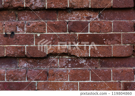 The brick wall of the castle is damaged. Brick wall background. Brick background 119804860