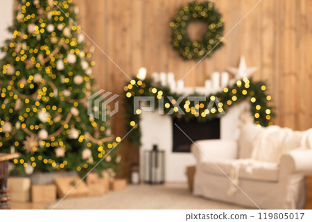 Blurred cozy Christmas living room with a decorated tree, garland on the fireplace, and festive lights, creating a warm holiday atmosphere Blurred cozy Christmas living room with a decorated tree, garland on the fireplace, and festive lights, creating a warm holiday atmosphere 119805017