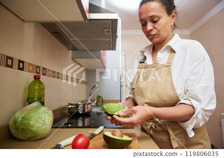Woman preparing a fresh avocado salad in the kitchen Woman preparing a fresh avocado salad in the kitchen 119806035