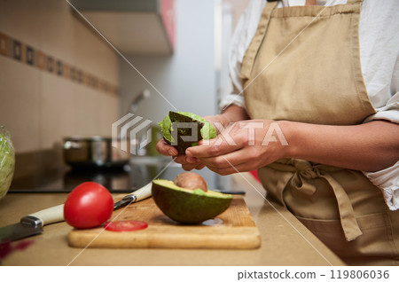 Person preparing fresh avocado salad in home kitchen Person preparing fresh avocado salad in home kitchen 119806036