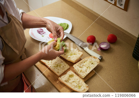 Person preparing fresh avocado sandwiches in a home kitchen Person preparing fresh avocado sandwiches in a home kitchen 119806066