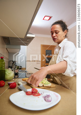 Woman preparing fresh ingredients in a modern kitchen Woman preparing fresh ingredients in a modern kitchen 119806073