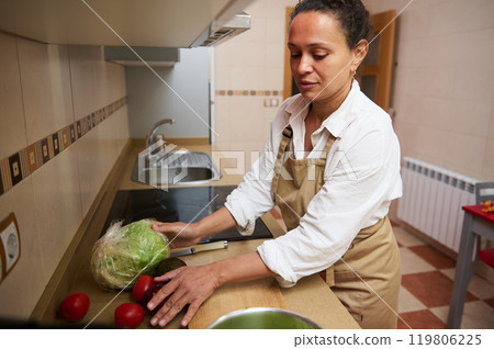 Woman preparing fresh vegetables in a modern kitchen setting Woman preparing fresh vegetables in a modern kitchen setting 119806225
