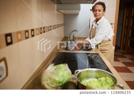 Woman preparing food in kitchen with fresh ingredients Woman preparing food in kitchen with fresh ingredients 119806235
