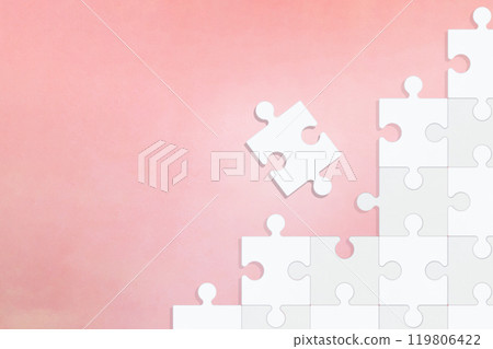 A pink background with one piece of a white stepped puzzle falling into place A pink background with one piece of a white stepped puzzle falling into place 119806422