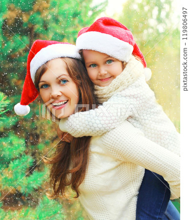 Christmas family child hugging mother in santa red hats together Christmas family child hugging mother in santa red hats together 119806497