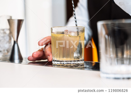 Crafting a refreshing cocktail during an evening gathering at a bar 119806826