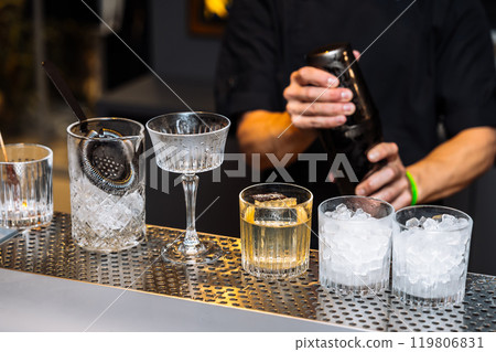 Crafting cocktails and tasting fine spirits at a bar during a lively evening 119806831