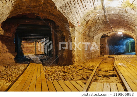 Exploring The Enigmatic Old Abandoned Mine Tunnel Featuring A Wooden Walkway And Rusty Tracks Exploring The Enigmatic Old Abandoned Mine Tunnel Featuring A Wooden Walkway And Rusty Tracks 119806998