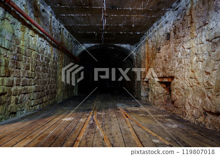 Old creepy dark scary underground tunnel with brick walls and wooden floor 119807018