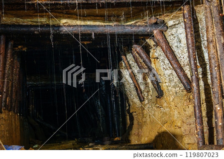 Gloomy and dark abandoned gold mine tunnel with wooden supports, gold mine 119807023