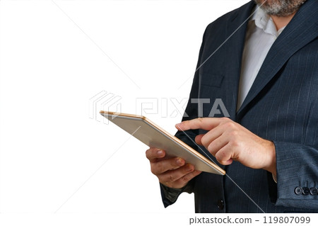 Professional businessman in a formal suit using a tablet device against a solid color backdrop Professional businessman in a formal suit using a tablet device against a solid color backdrop 119807099
