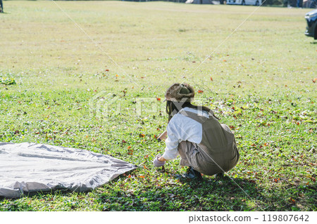 Woman setting up a tent 119807642