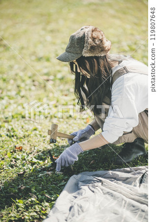 Woman setting up a tent 119807648