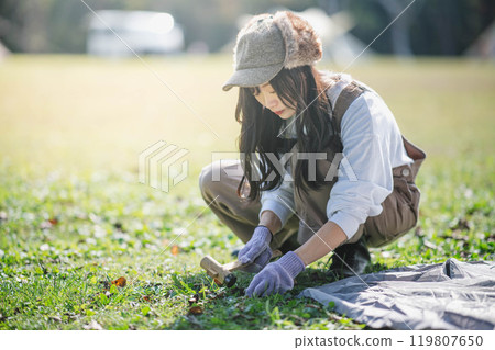 Woman setting up a tent 119807650