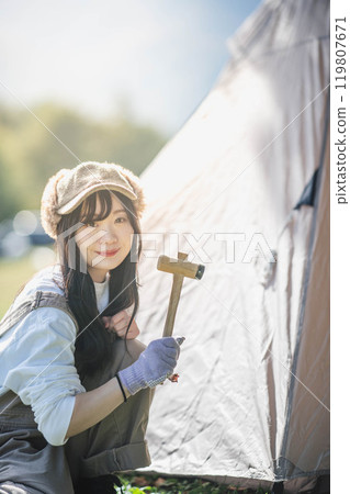 一位女士正在搭建帳篷 119807671