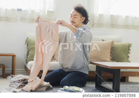 Men who fold laundry 119807898