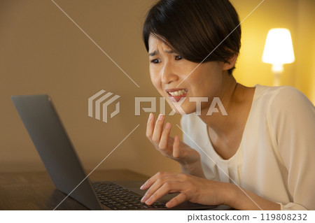 Business woman in the living room at night Business woman in the living room at night 119808232