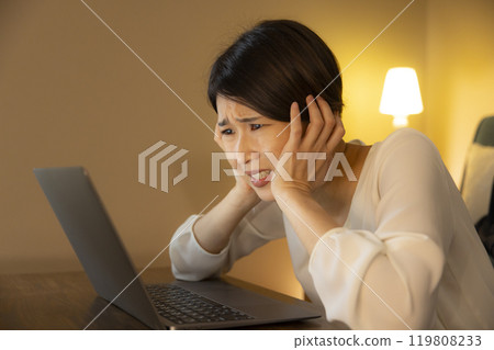 Business woman in the living room at night Business woman in the living room at night 119808233