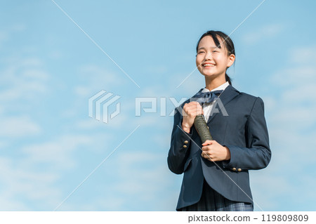 藍天下拿著圓形文憑管的國中畢業生女孩 119809809