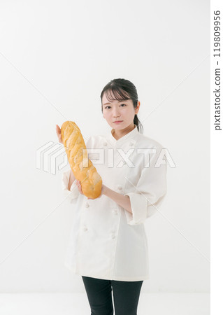 Portrait of a female chef holding French bread 119809956