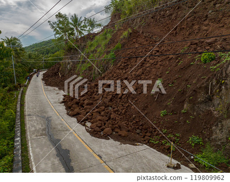 Heavy rainfall cause the landslides that block the half of the road. Camiguin, Philippines. 119809962