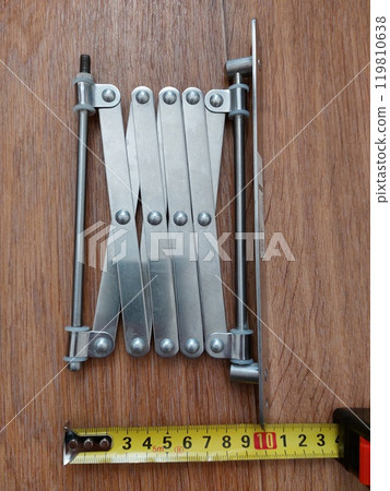 Tape measure measuring the length of a metal part Tape measure measuring the length of a metal part 119810638