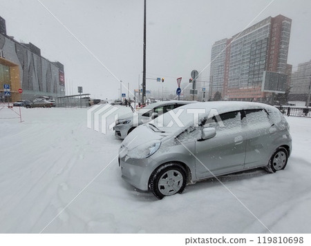 Cars parked in the snow near a shopping mall 119810698