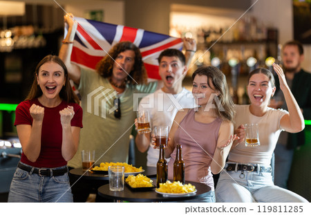 Emotional United Kingdom fans with national flag watch the match on TV with interest and actively comment 119811285