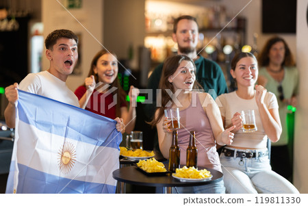 Group of emotional Argentine fans with the national flag watch the match on TV with interest and actively comment 119811330
