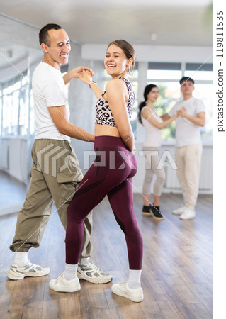 Girl paired up with young man, they train to perform disco fox dance, rehearse performance. Girl paired up with young man, they train to perform disco fox dance, rehearse performance. 119811535