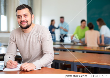 Portrait of positive adult student in the university auditorium during break 119811596