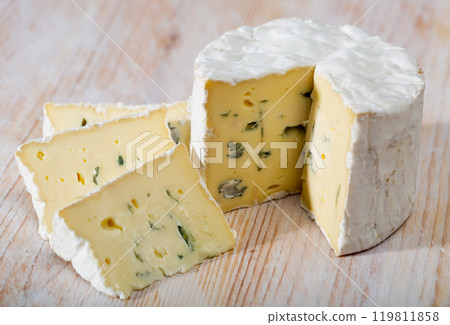 Slices of tasty soft blue cheese with blue mold at wooden board 119811858