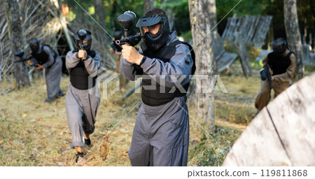 Man shooting with paintball marker outdoors Man shooting with paintball marker outdoors 119811868