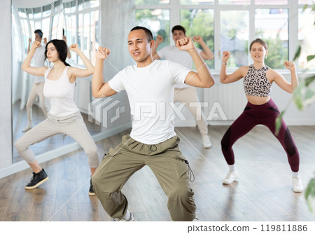 Expressive Asian guy honing hip-hop dance moves in studio 119811886