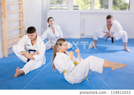 Young female karate practitioner training blocks lying in press position 119812031