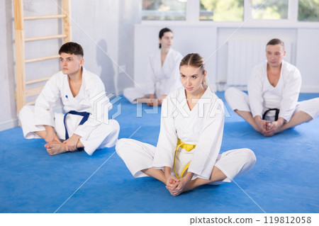 Group of people practicing butterfly pose in studio 119812058