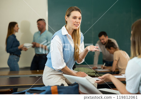 Group of students talking in classroom having break between lessons Group of students talking in classroom having break between lessons 119812061
