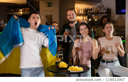 Group of fans in bar with Ukrainian flag Group of fans in bar with Ukrainian flag 119812067