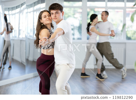 Girl paired up with young man, they train to perform hustle dance, rehearse performance. 119812290