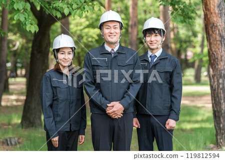 Male and female workers in forestry and civil engineering work clothes in the forest 119812594