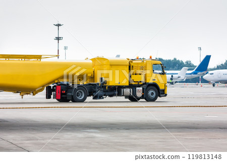 Yellow tank truck aircraft refueler at the airport apron 119813148