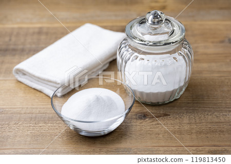 木桌上排列著玻璃瓶和碗中的白色小蘇打粉和洗碗巾 木桌上排列著玻璃瓶和碗中的白色小蘇打粉和洗碗巾 119813450