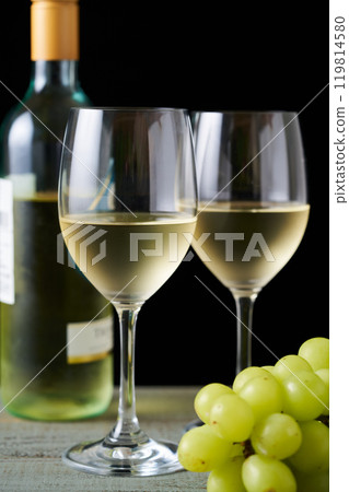 white wine poured into a glass 119814580