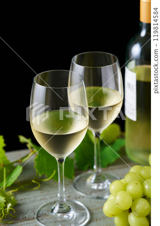 white wine poured into a glass 119814584